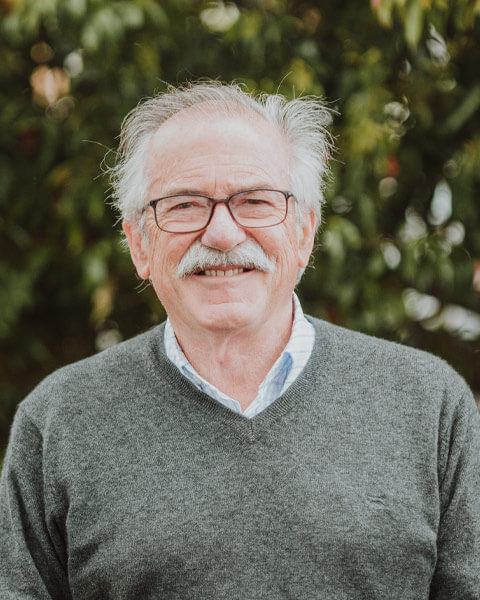 Chris-obrien-team-chrisobrien Photo of Chris O'Brien wearing a olive green jumper standing infront of green trees.